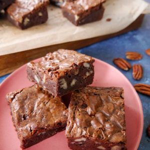 Pecan brownies with pecan pieces on a pink plate