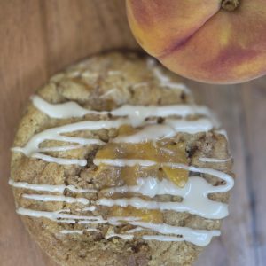 Peach cobbler cookie topped with peach pieces and icing drizzle